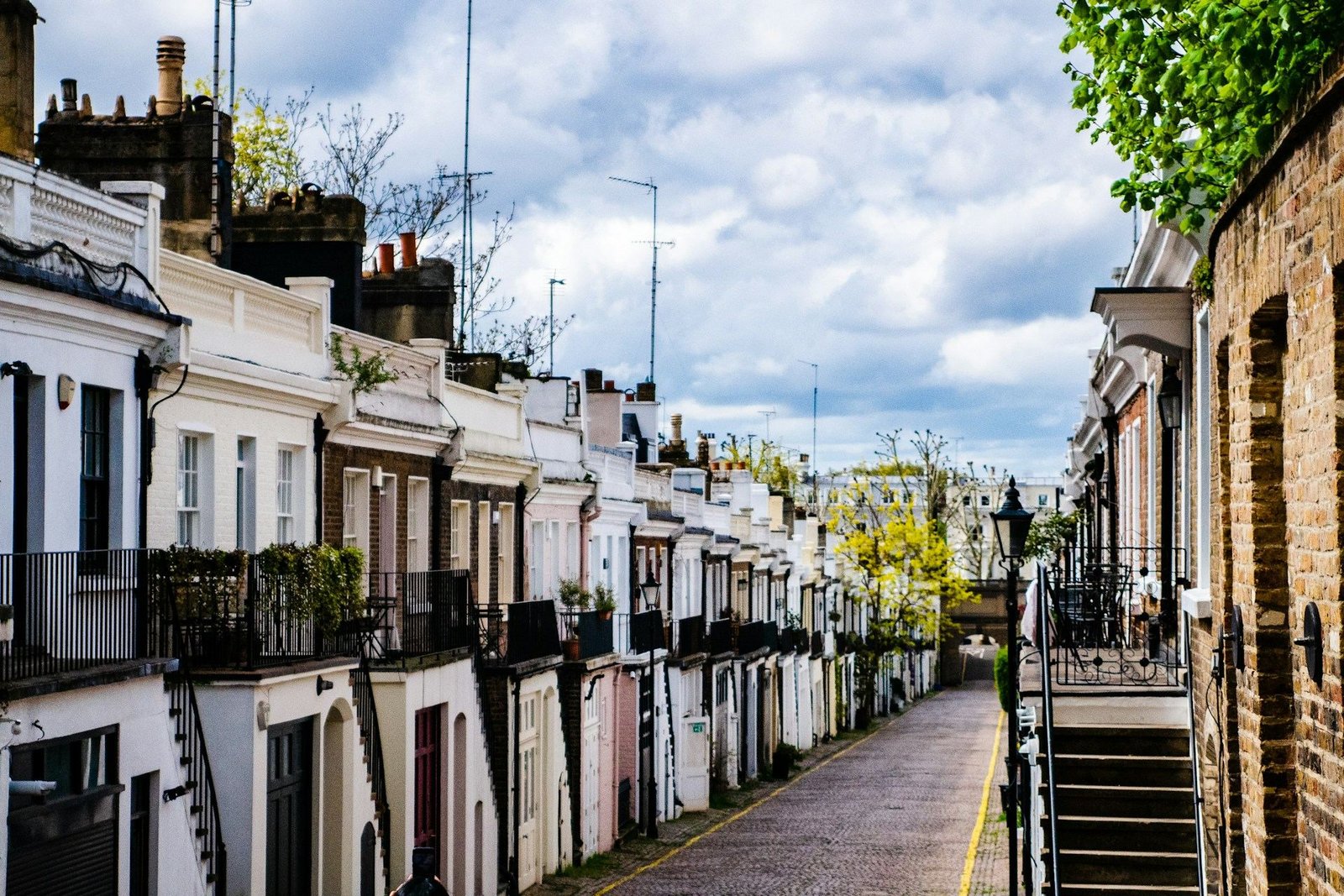 Narrow cobbled lane lined with white terraced houses