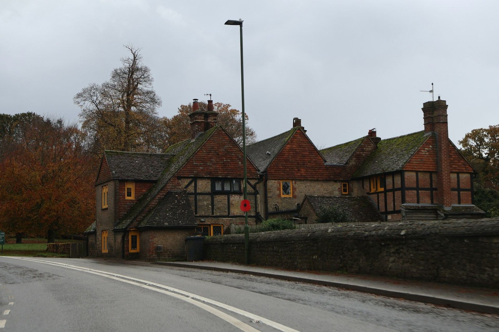 Tudor-style brick houses beside a quiet road in autumn