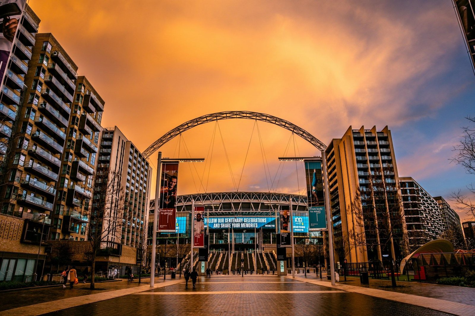 Wembley Stadium arch at sunset between apartment blocks