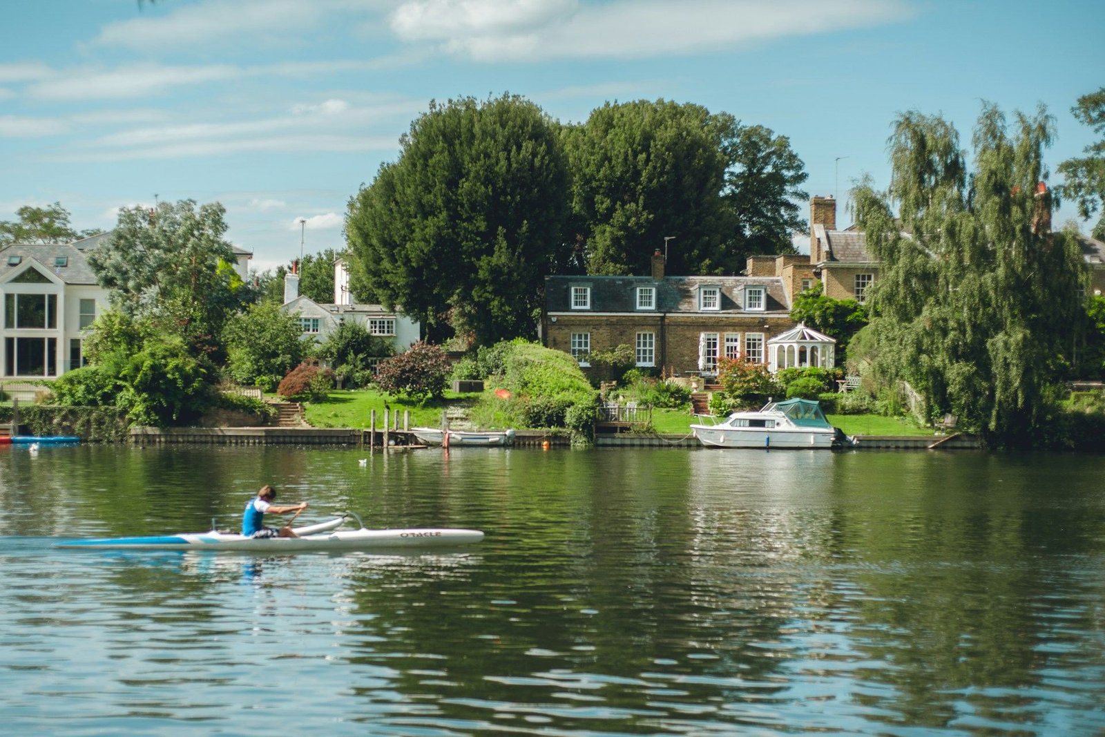 Rower on the Thames past riverside houses