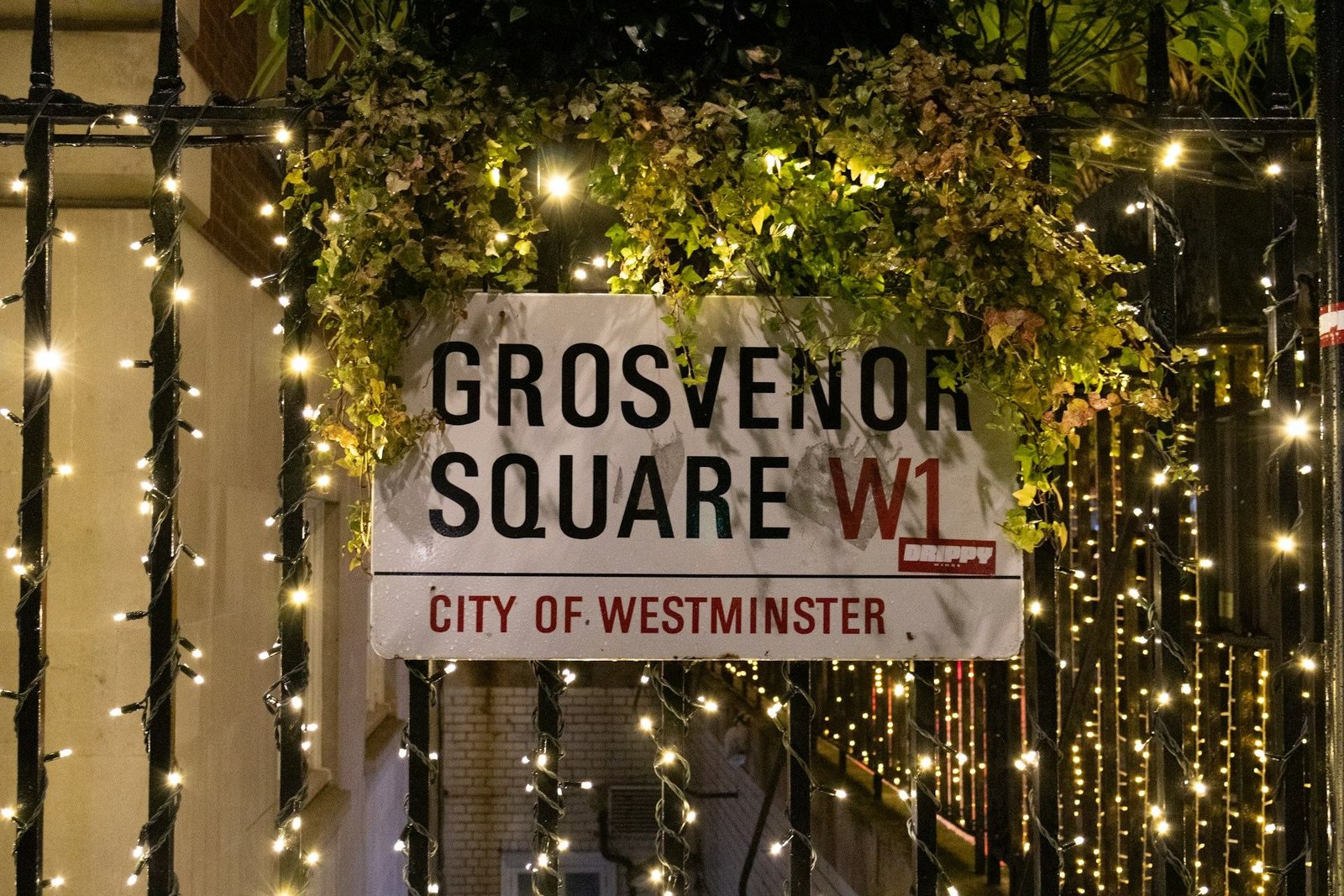 Grosvenor Square W1 street sign framed by fairy lights