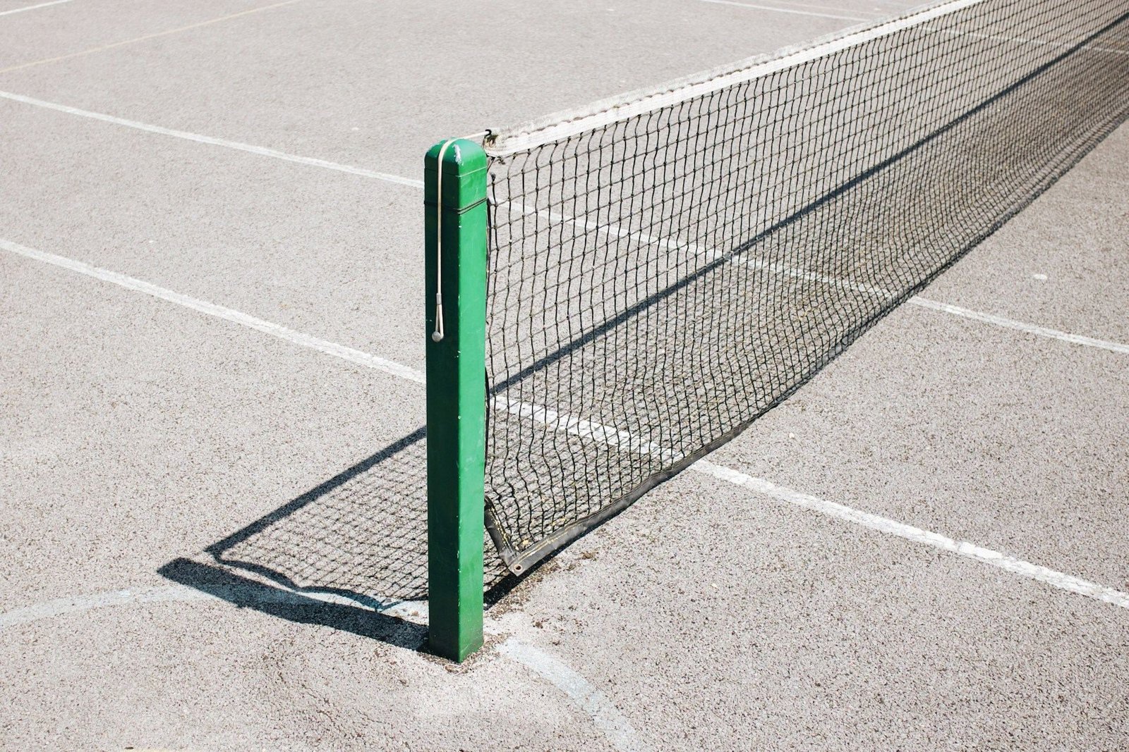 Tennis net and post on a hard court
