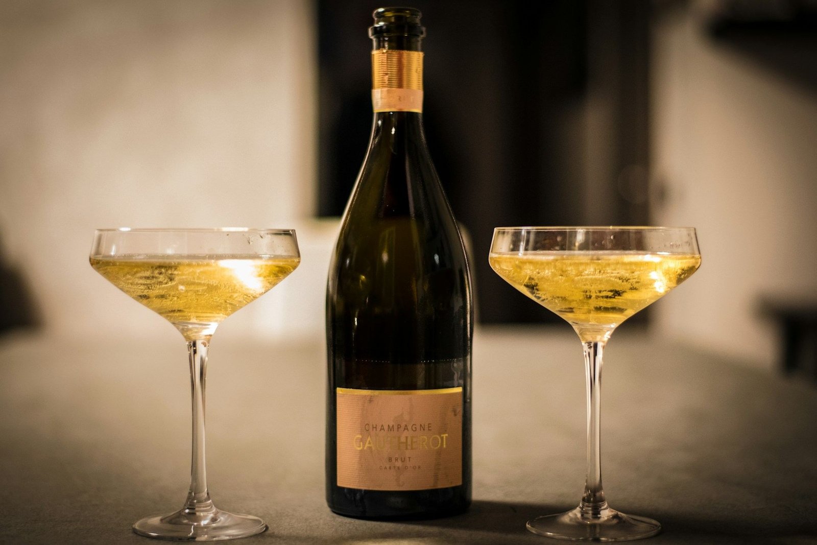 Bottle of champagne between two coupe glasses