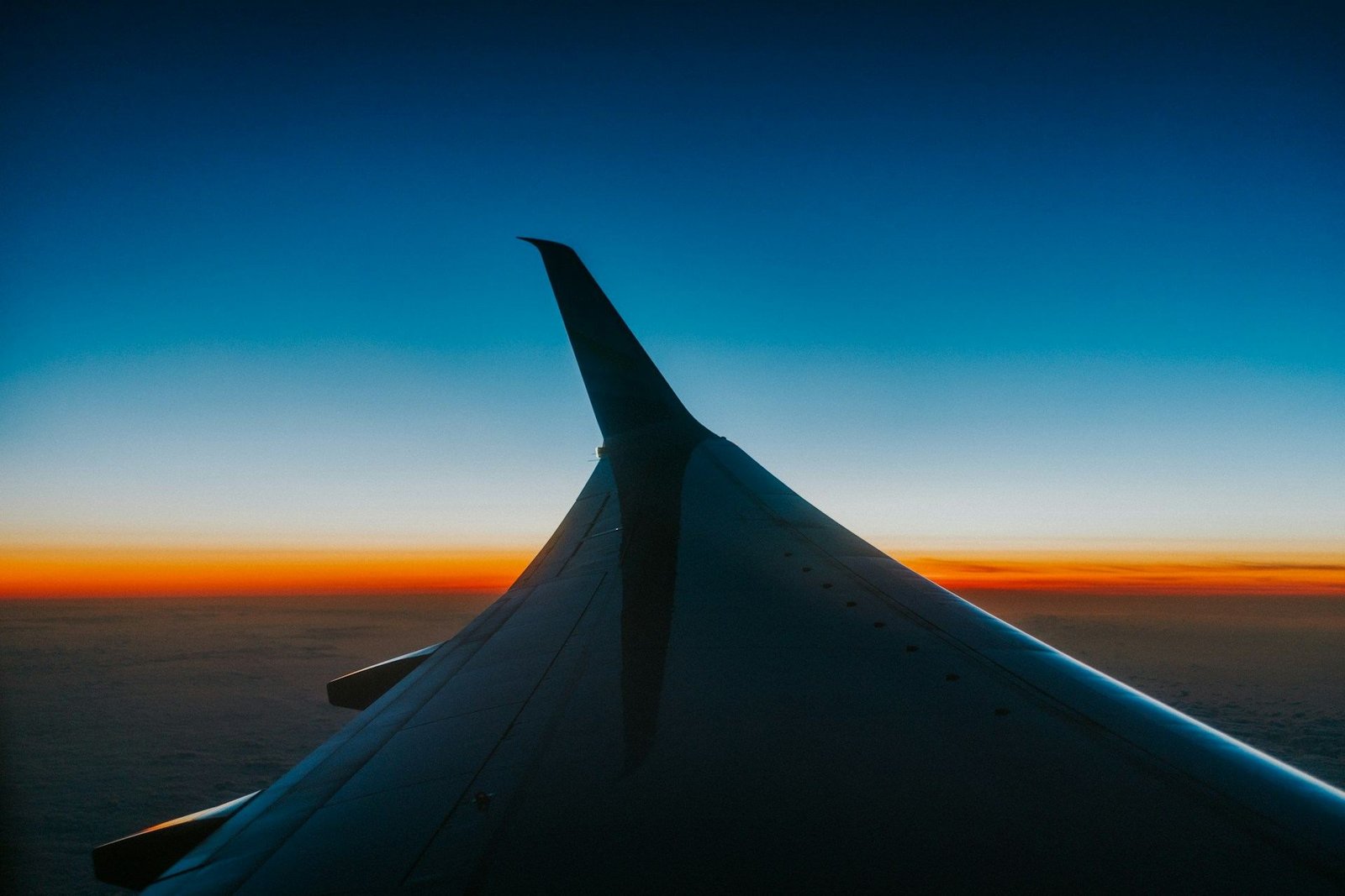Aircraft wing against an orange sunset sky
