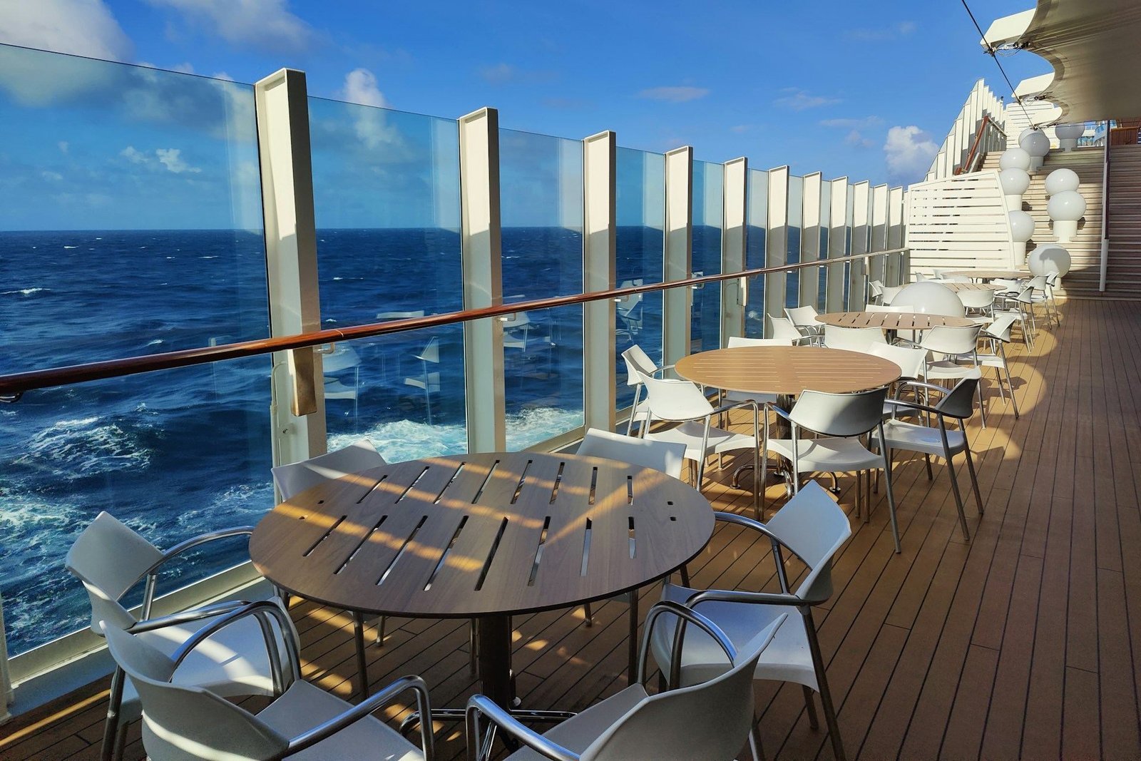 Tables and chairs on the open deck of a cruise ship