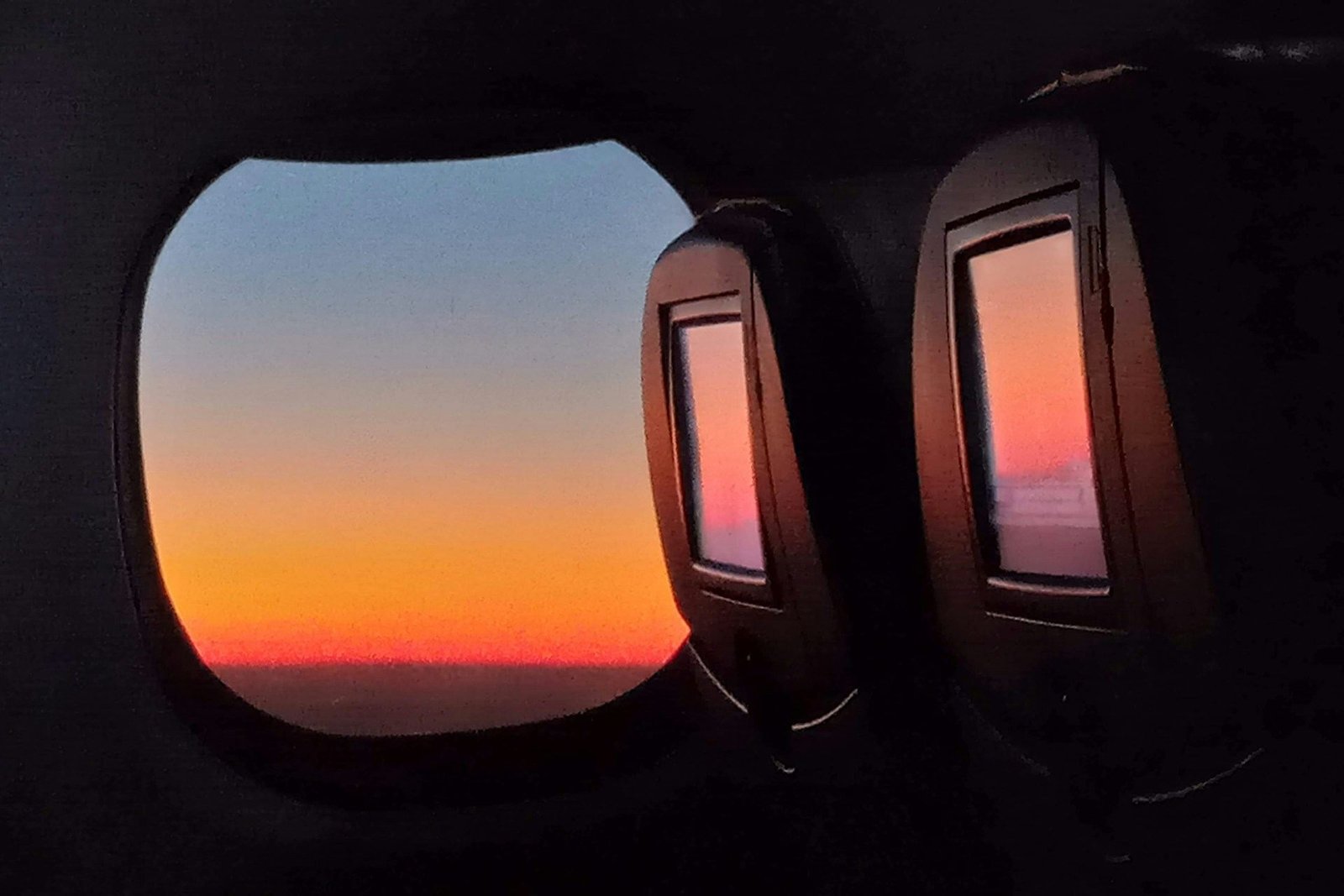 Sunrise through the oval windows of a private jet